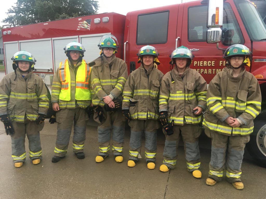Pierce Fire Department cadets in turnout gear in front of a fire truck
