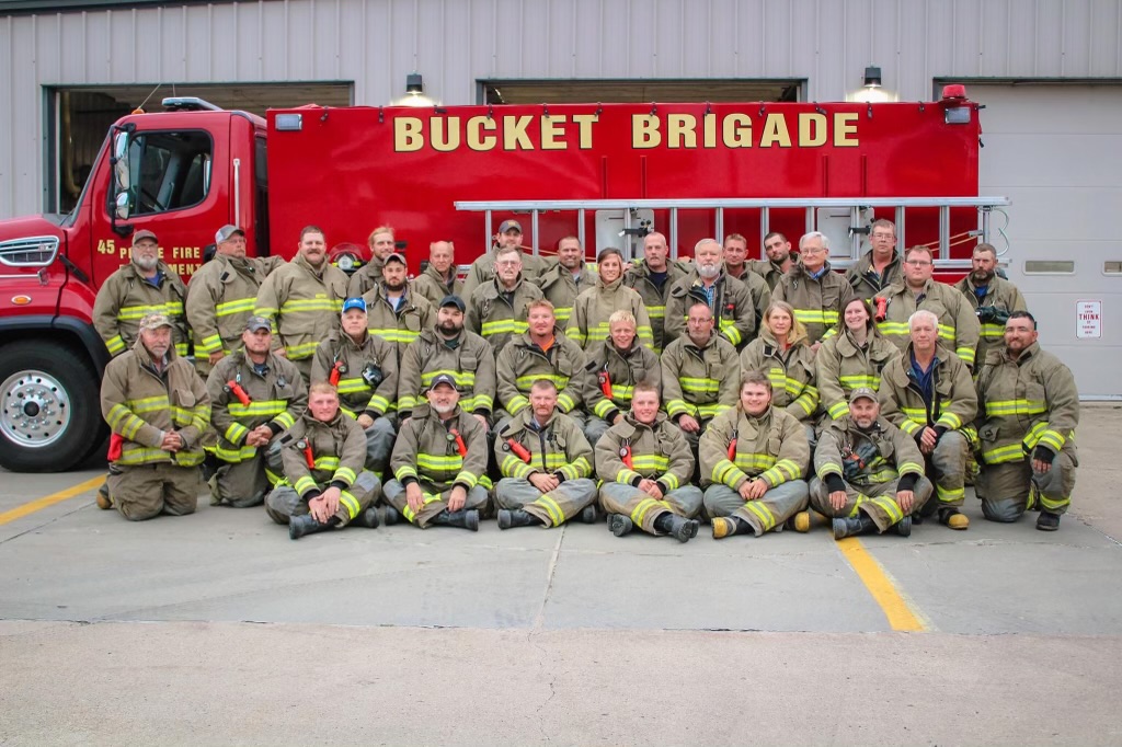 Pierce Volunteer Fire Department members in front of a red fire truck
